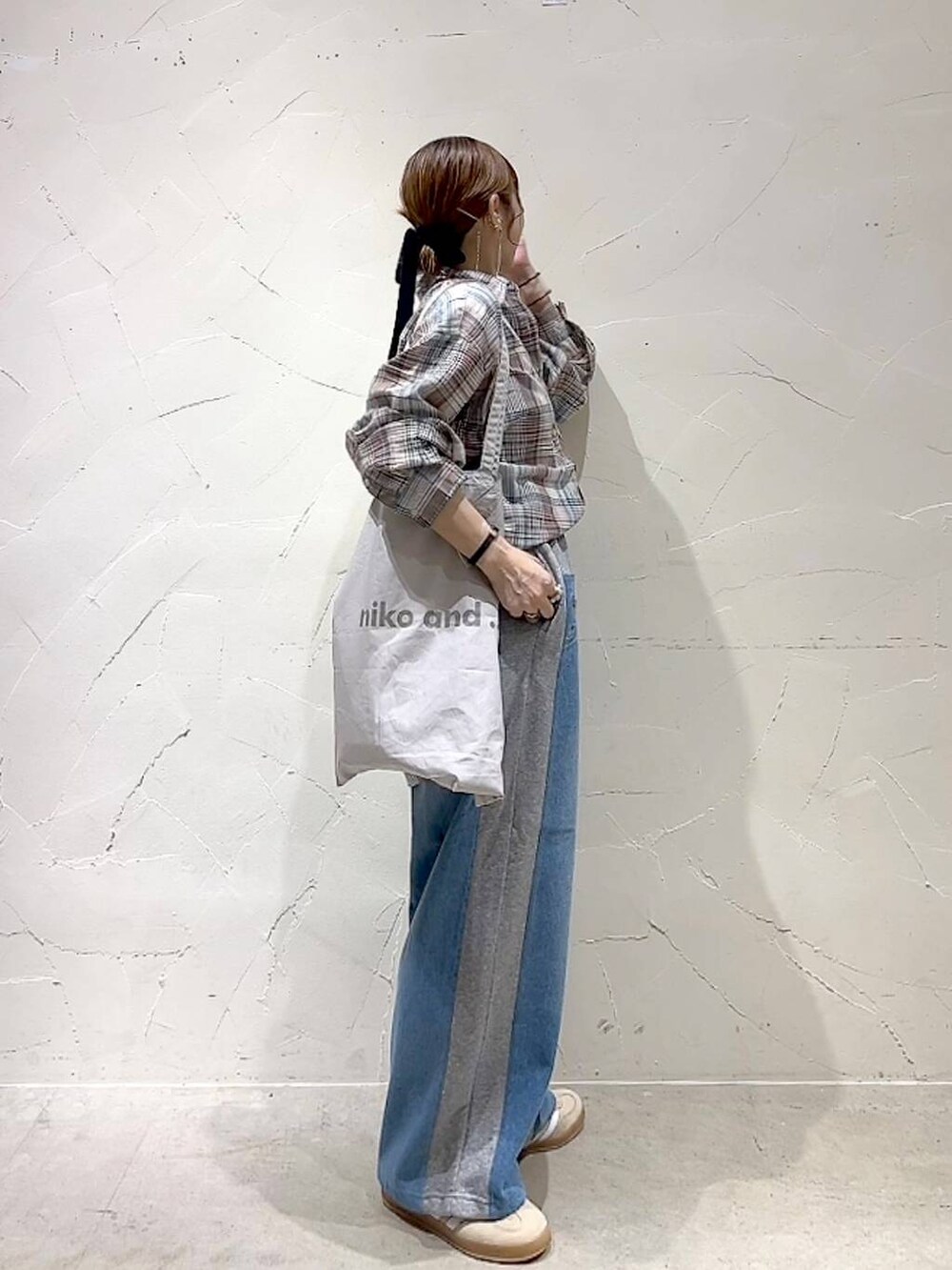 ベージュ系のシャツ/ブラウス、グレー系のトートバッグ、グレー系のデニムパンツを着用したレディースの夏コーディネートの4枚目の写真