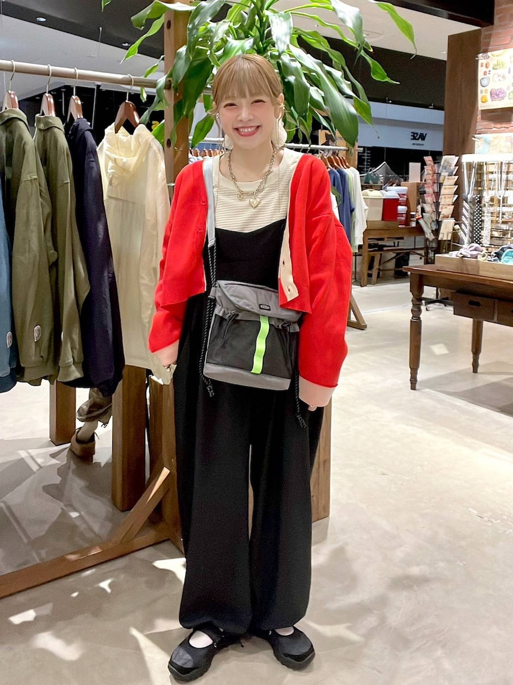 レッド系のカーディガン/ボレロ、ホワイト系のヘアゴムを着用したレディースの春コーディネートの6枚目の写真