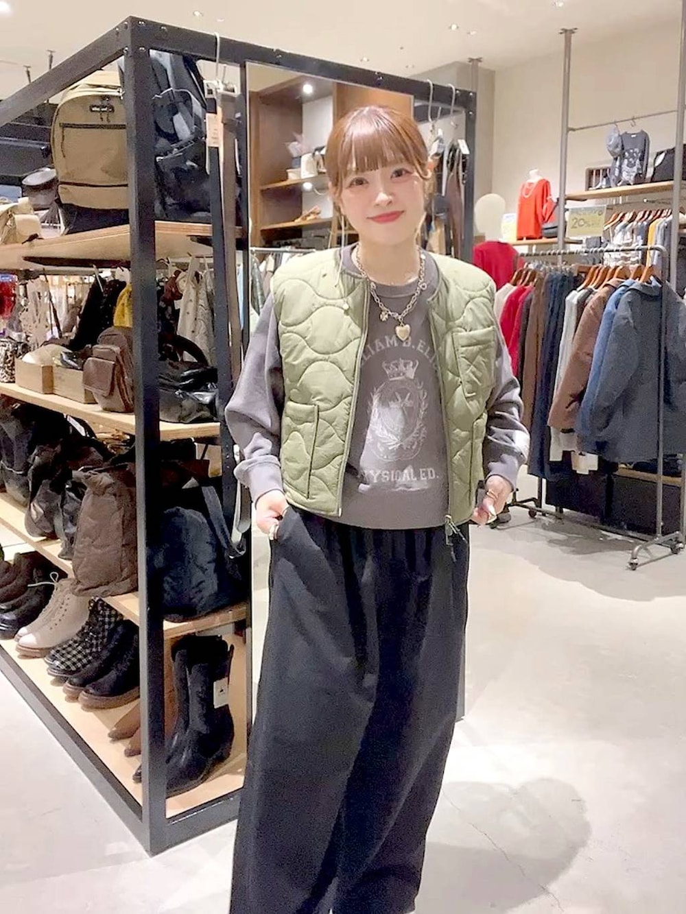 グリーン系のベスト、グレー系のTシャツ/カットソーを着用したレディースの秋コーディネートの3枚目の写真