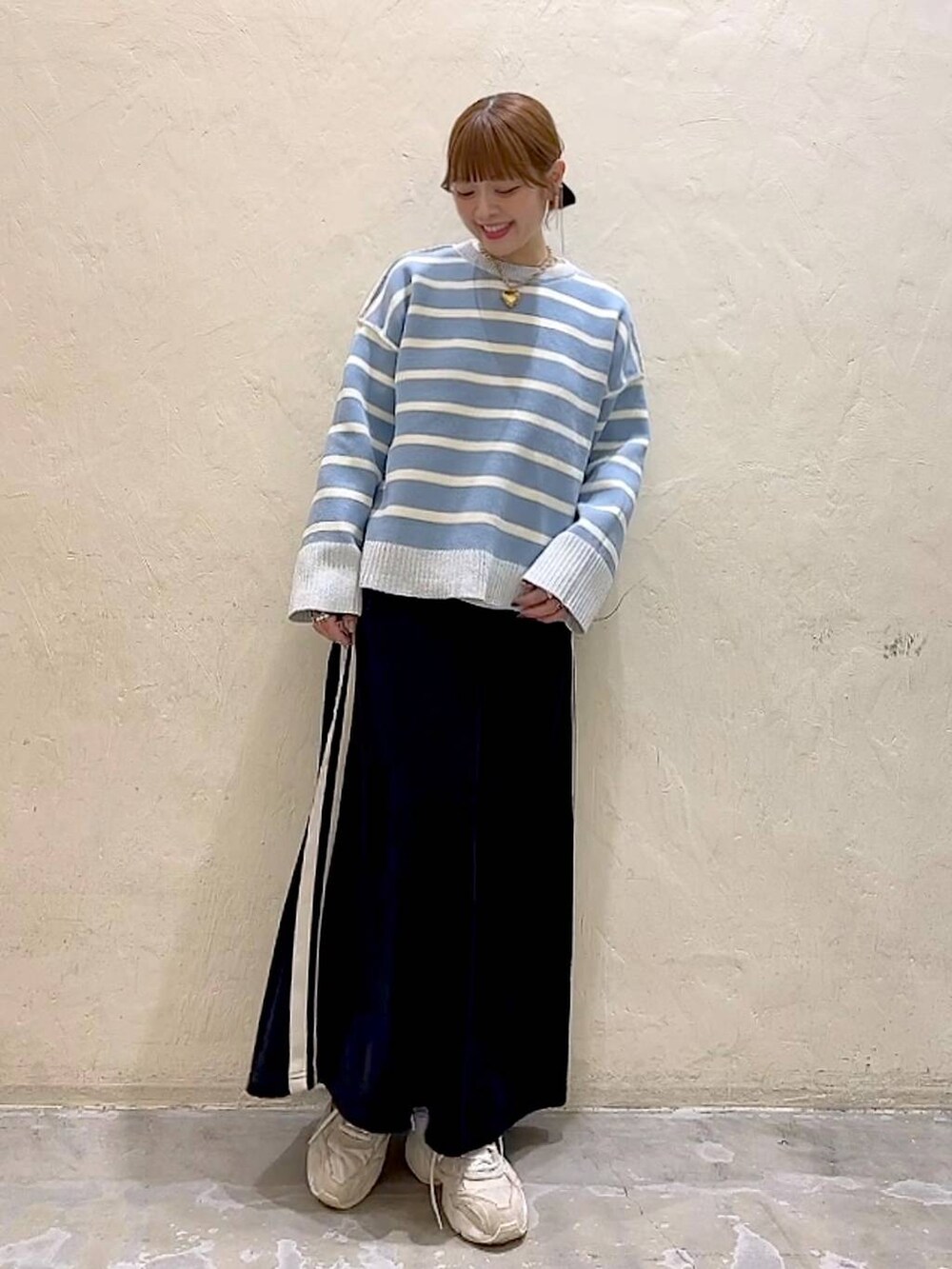 ホワイト系のTシャツ/カットソー、ブラック系のスカート、ベージュ系のニット/セーターを着用したレディースの冬コーディネートの9枚目の写真