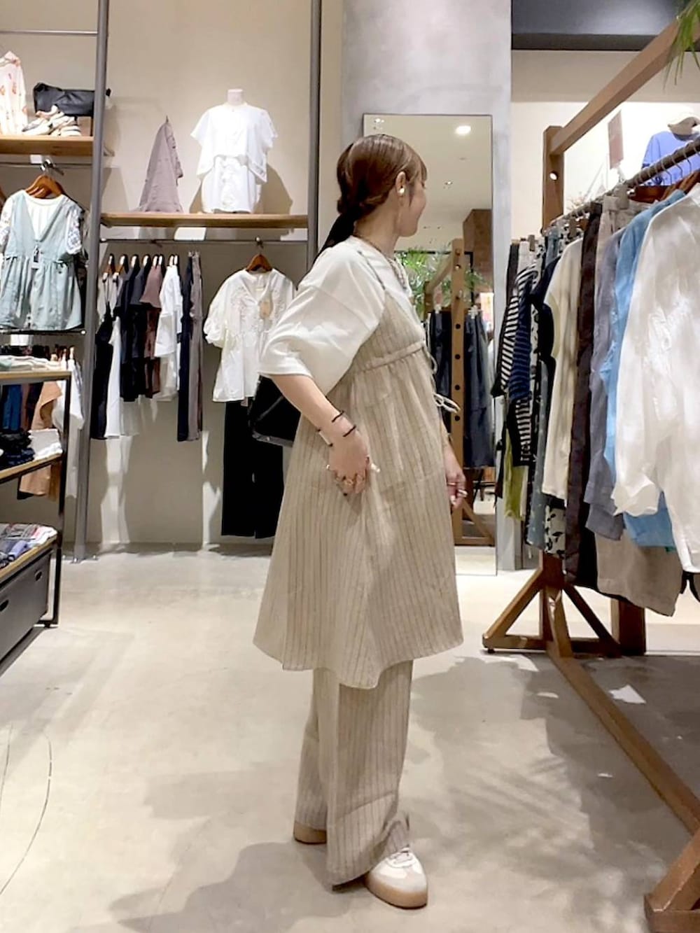 ブラック系のショルダーバッグ、ホワイト系のTシャツ/カットソー、ベージュ系のその他雑貨を着用したレディースの夏コーディネートの4枚目の写真