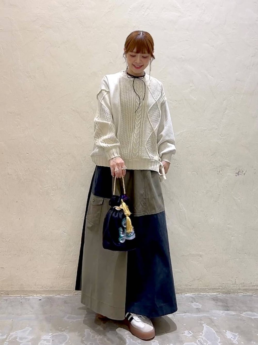 その他のショルダーバッグ、ベージュ系のニット/セーター、グリーン系のスカートを着用したレディースの冬コーディネートの3枚目の写真