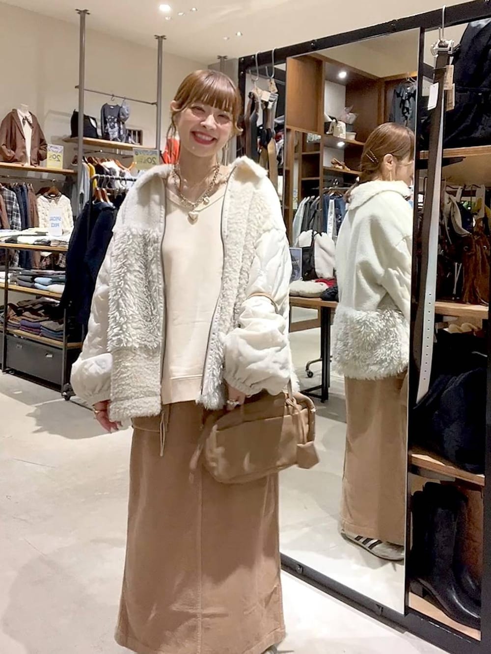 ベージュ系のブルゾン、イエロー系のスカート、ベージュ系のボストンバッグを着用したレディースの秋コーディネートの3枚目の写真