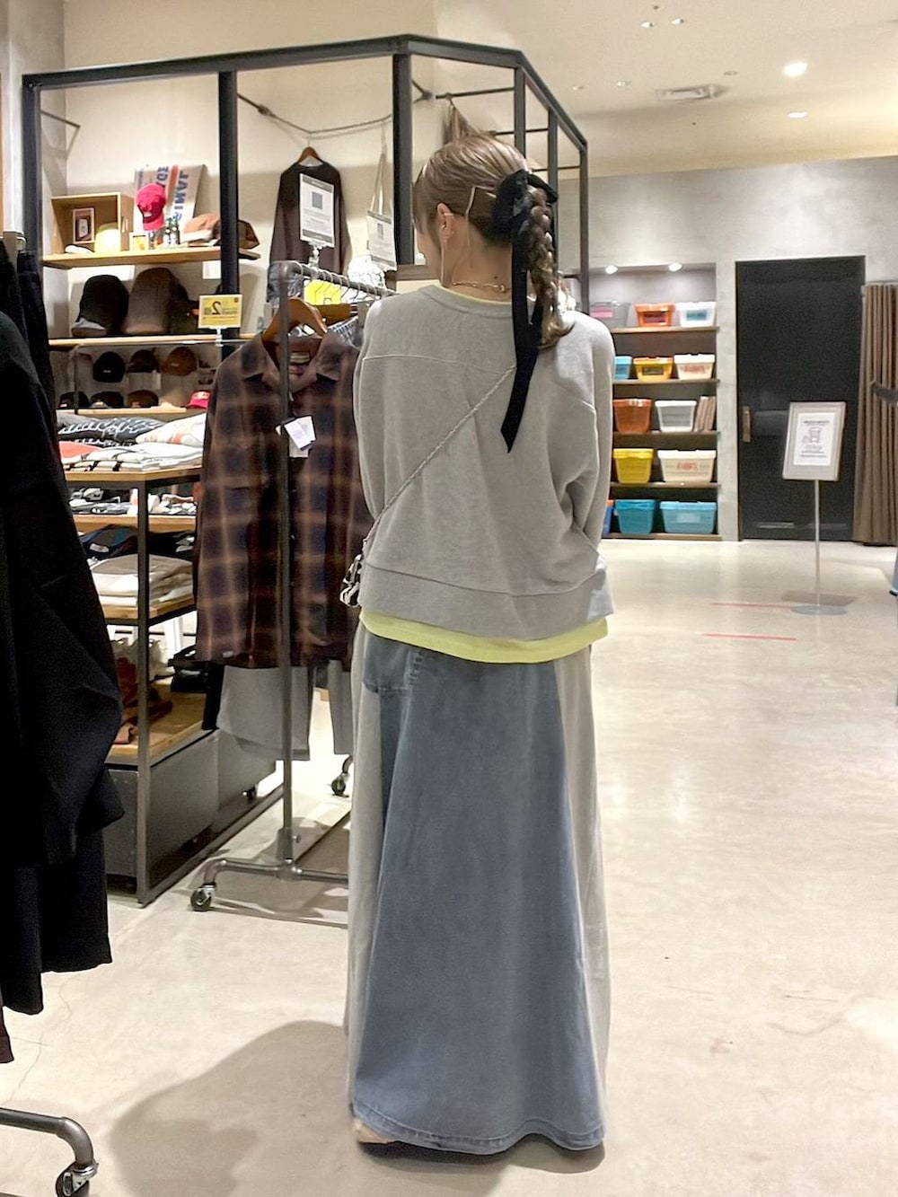 ベージュ系のパンプス、グレー系のスウェット、ブルー系のデニムスカートを着用したレディースの秋コーディネートの4枚目の写真
