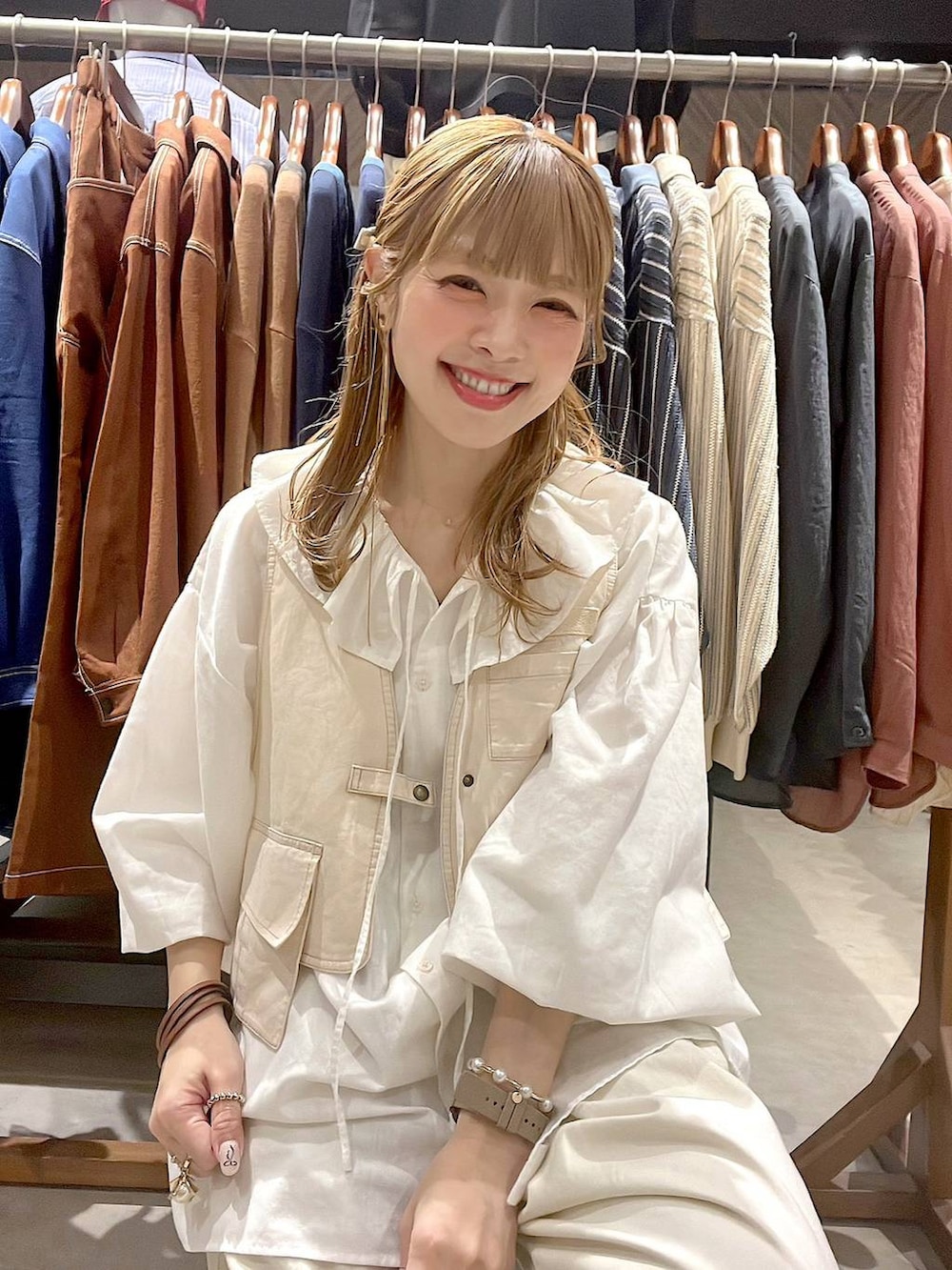 ホワイト系のシャツ/ブラウス、イエロー系のブレスレット、グリーン系のアナログ腕時計を着用したレディースの春コーディネートの2枚目の写真