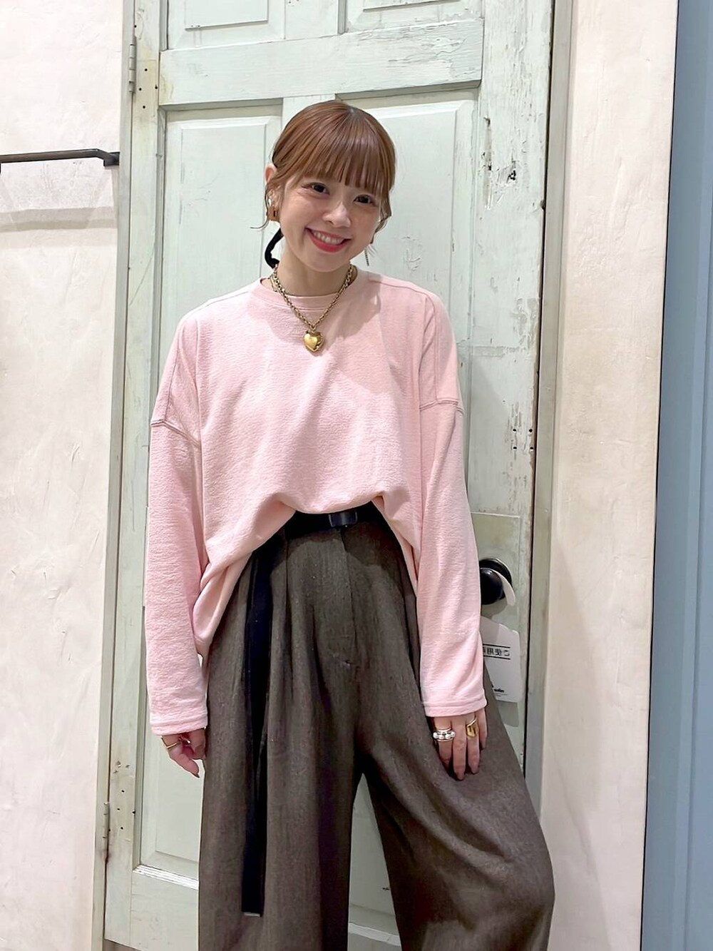 ブラウン系のその他パンツ、ピンク系のTシャツ/カットソー、イエロー系のリングを着用したレディースの冬コーディネートの8枚目の写真