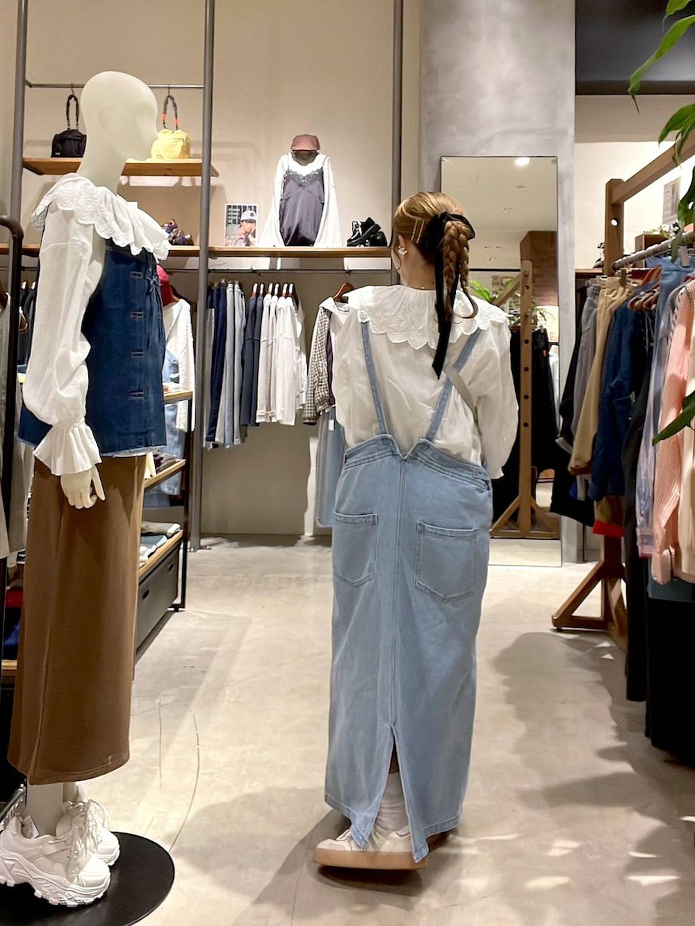 ブルー系のジャンパースカート、ベージュ系のTシャツ/カットソー、ホワイト系のシャツ/ブラウスを着用したレディースの冬コーディネートの6枚目の写真