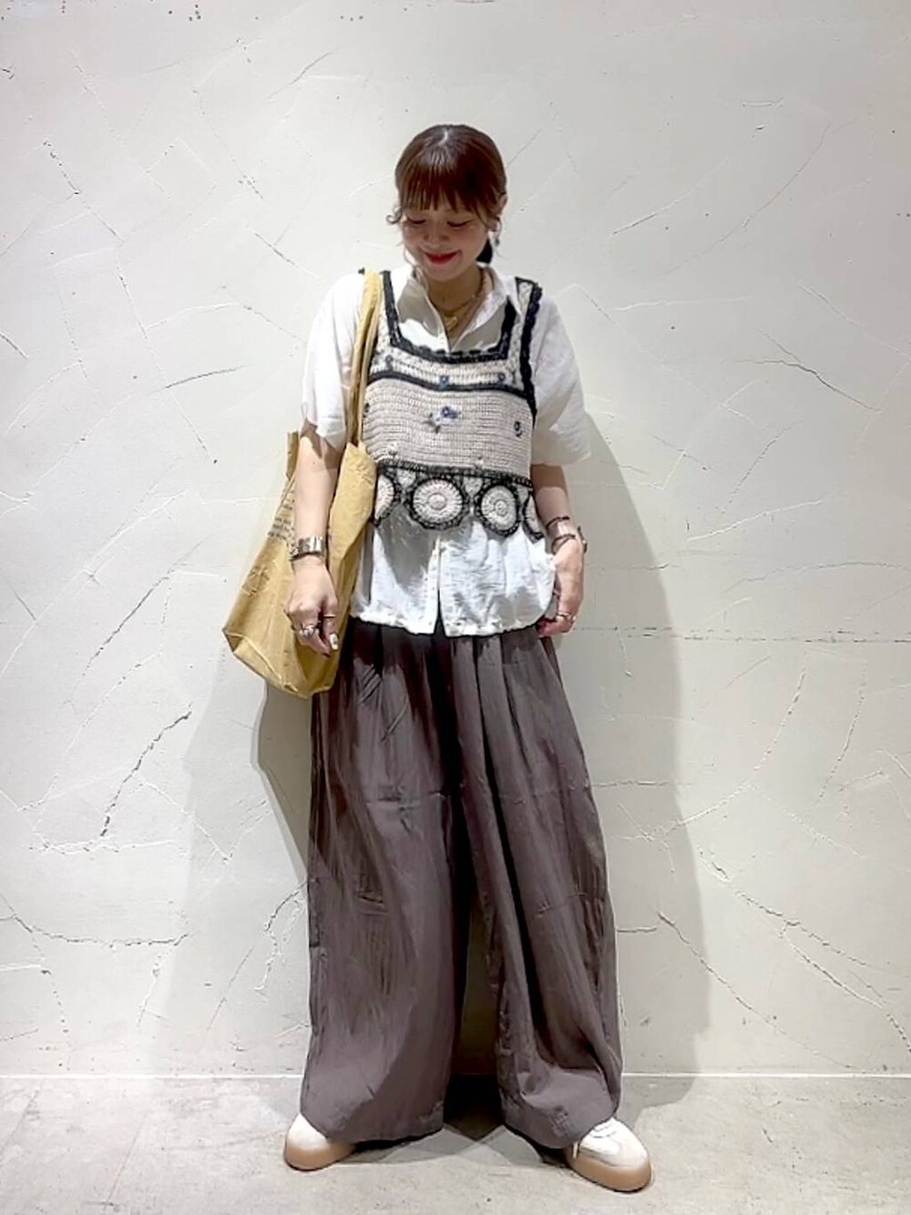 イエロー系のトートバッグ、ホワイト系のキャミソール、ホワイト系のシャツ/ブラウスを着用したレディースの夏コーディネートの9枚目の写真