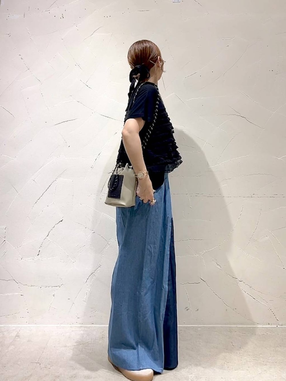 グレー系のショルダーバッグ、ブラック系のTシャツ/カットソー、ゴールド系のネックレスを着用したレディースの秋コーディネートの4枚目の写真