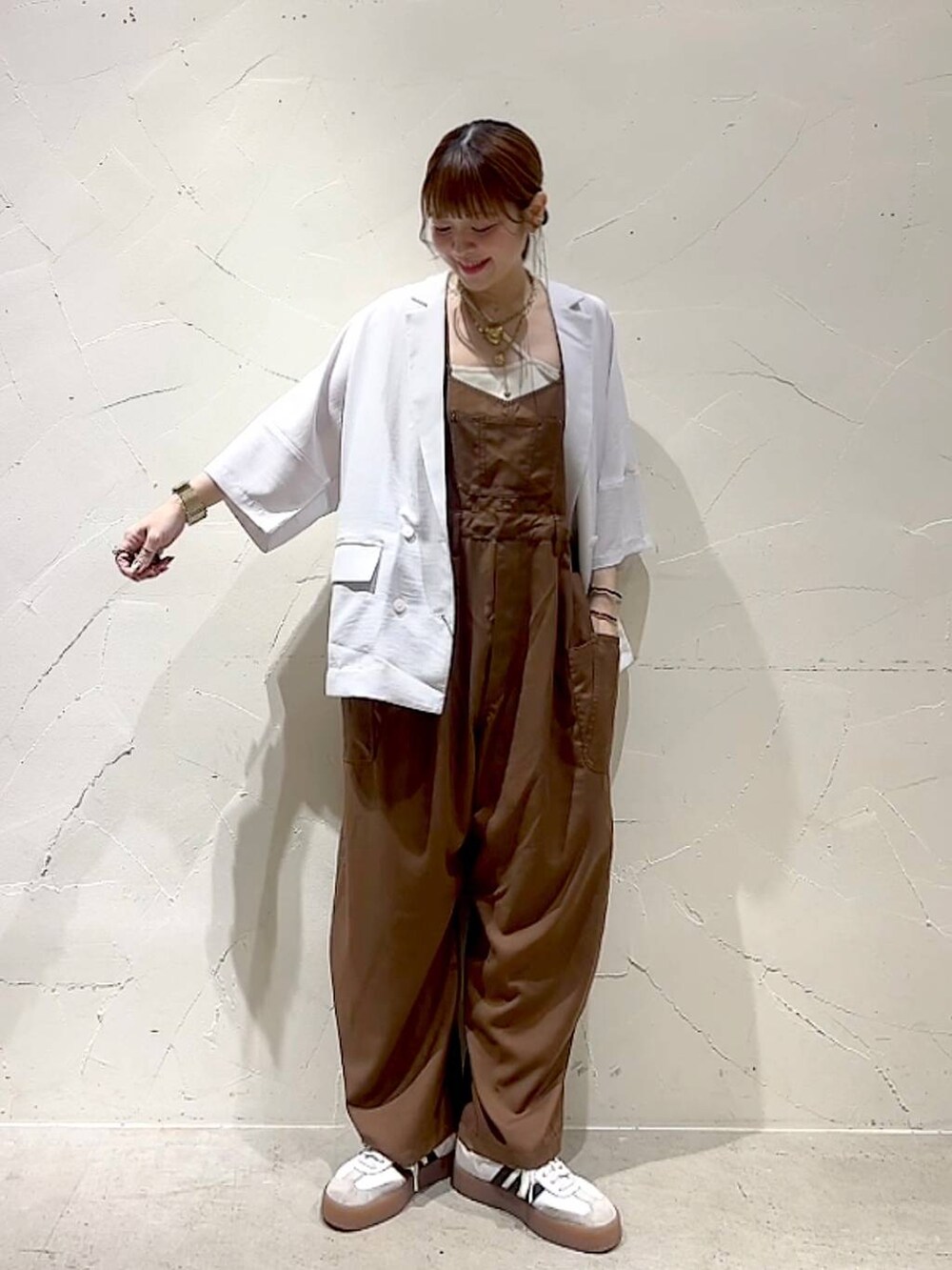 ベージュ系のテーラードジャケット、イエロー系のアナログ腕時計、ベージュ系のネックレスを着用したレディースの春コーディネートの4枚目の写真