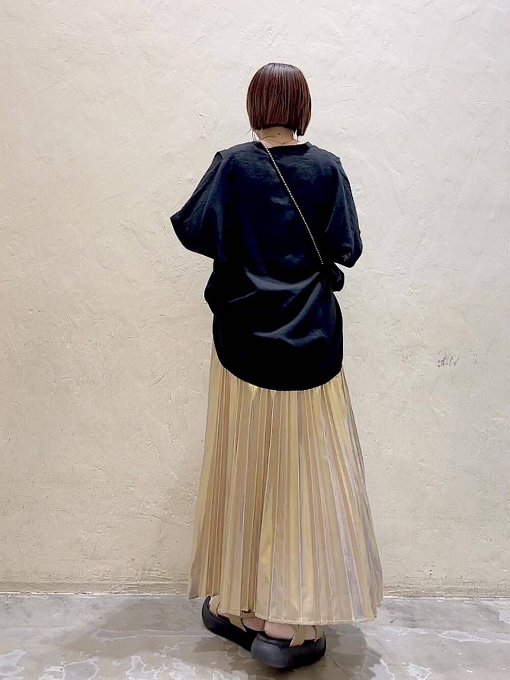 ブラック系のショルダーバッグ、イエロー系のサンダル、イエロー系のスカートを着用したレディースの夏コーディネートの3枚目の写真