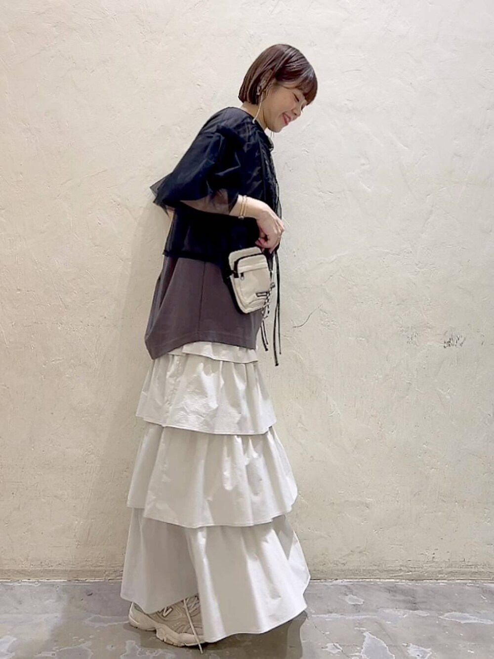 ブラック系のその他トップス、その他のTシャツ/カットソー、ベージュ系のショルダーバッグを着用したレディースの春コーディネートの3枚目の写真