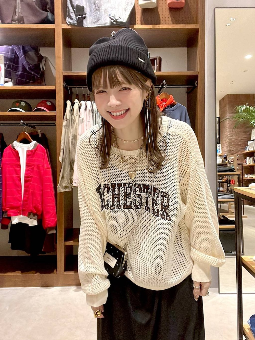 ブラック系のワンピース、ベージュ系のニット/セーター、ブラック系の財布を着用したレディースの秋コーディネートの3枚目の写真