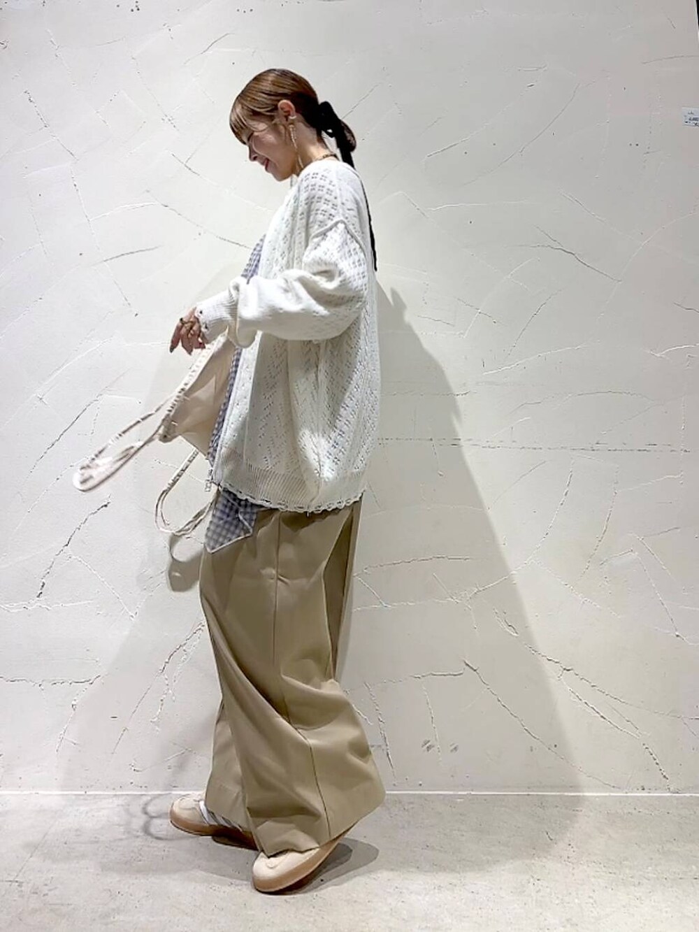 ベージュ系のチノパンツ、ホワイト系のブルゾン、ホワイト系のキャミソールを着用したレディースの春コーディネートの6枚目の写真