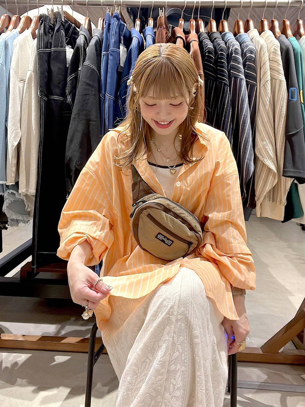 ベージュ系のスニーカー、ベージュ系のボディバッグ/ウエストポーチ、ベージュ系のキャミソールを着用したレディースの春コーディネートの7枚目の写真