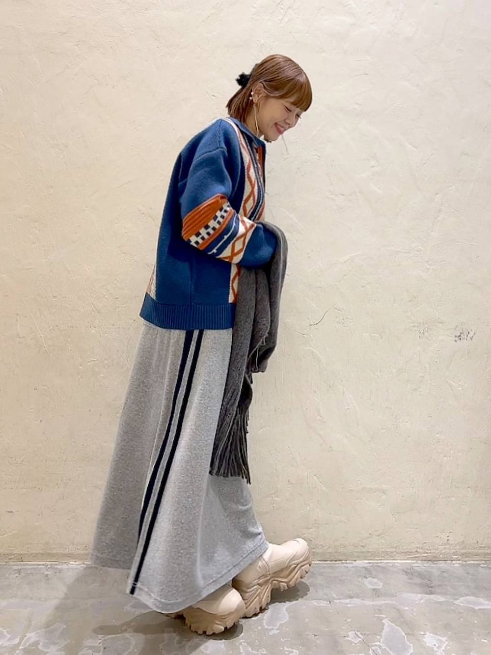 ブルー系のニット/セーター、グレー系のストール/ショール、ブラック系のバレッタ/ヘアクリップを着用したレディースの秋コーディネートの5枚目の写真