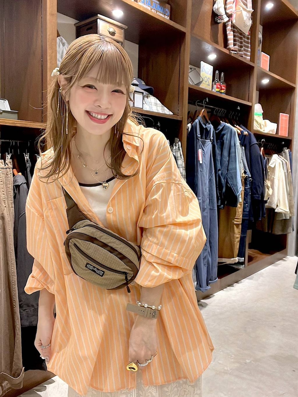 ベージュ系のスニーカー、ベージュ系のボディバッグ/ウエストポーチ、ベージュ系のキャミソールを着用したレディースの春コーディネートの4枚目の写真