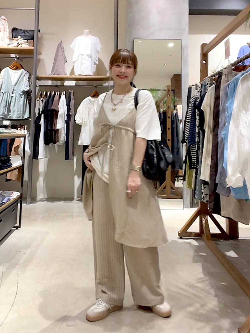 ブラック系のショルダーバッグ、ホワイト系のTシャツ/カットソー、ベージュ系のその他雑貨を着用したレディースの夏コーディネートの7枚目の写真