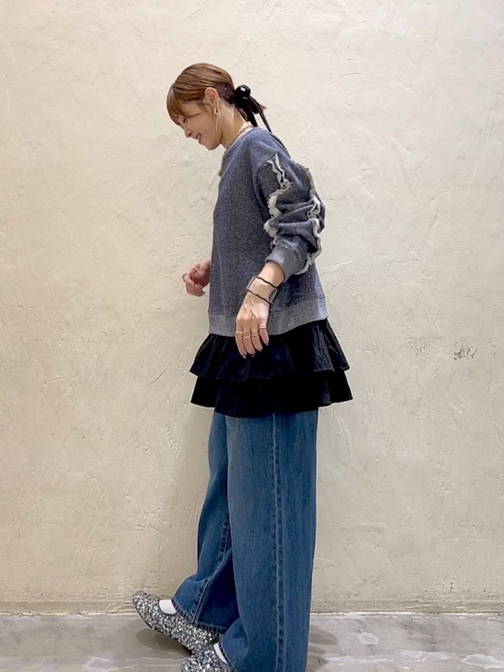 シルバー系のバレエシューズ、ブルー系のデニムパンツ、ブルー系のスウェットを着用したレディースの冬コーディネートの5枚目の写真