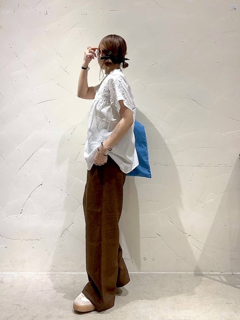 ブルー系のトートバッグ、ホワイト系のシャツ/ブラウス、ブラウン系のその他パンツを着用したレディースの夏コーディネートの6枚目の写真