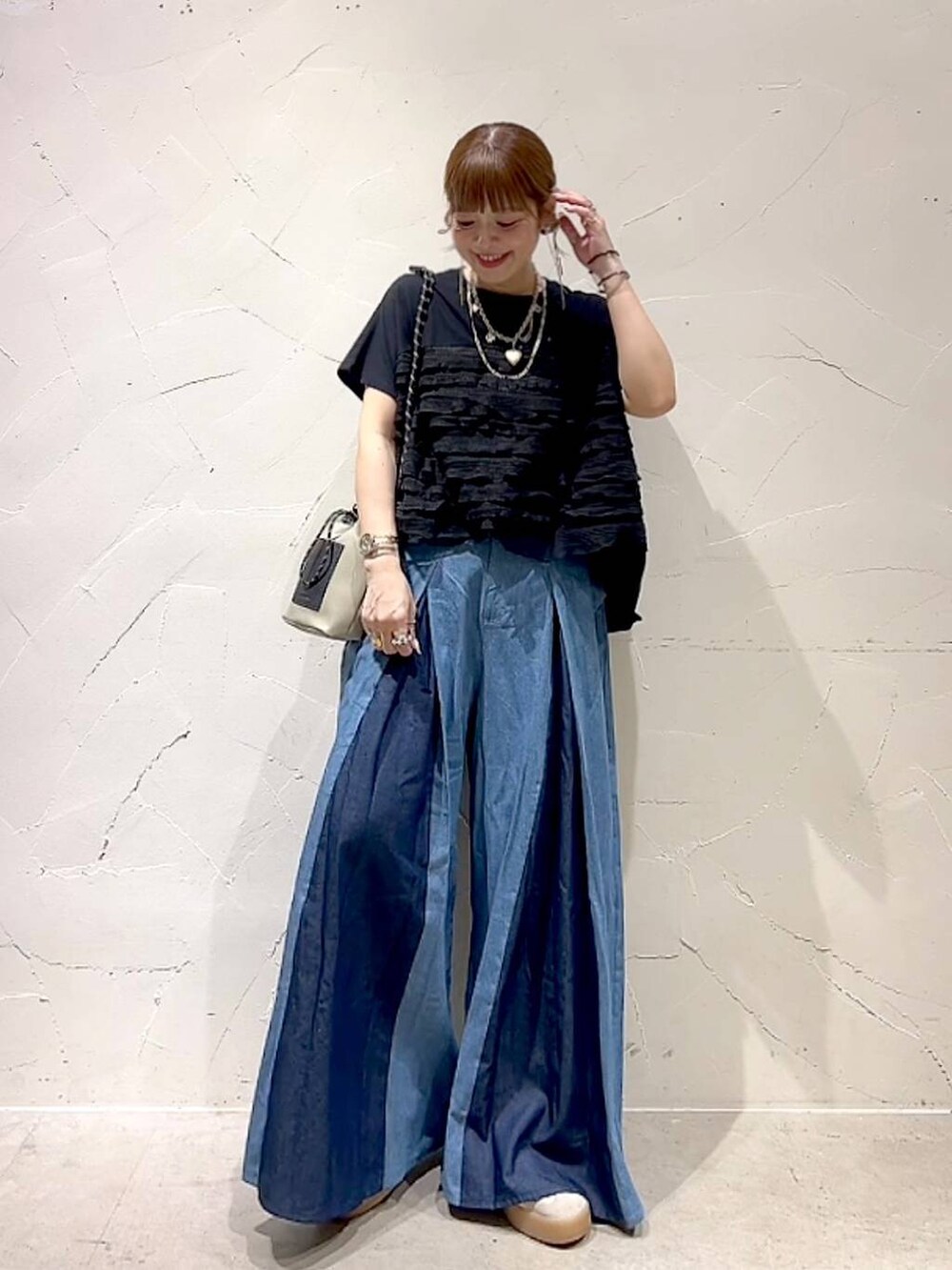 グレー系のショルダーバッグ、ブラック系のTシャツ/カットソー、ゴールド系のネックレスを着用したレディースの秋コーディネートの3枚目の写真