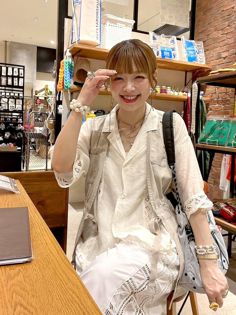 ベージュ系のベスト、ホワイト系のその他パンツ、その他のショルダーバッグを着用したレディースの夏コーディネートの5枚目の写真