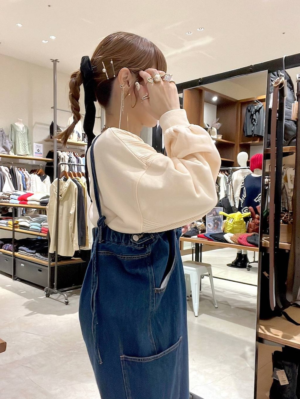 ベージュ系のショルダーバッグ、ブラック系のアナログ腕時計を着用したレディースの秋コーディネートの3枚目の写真