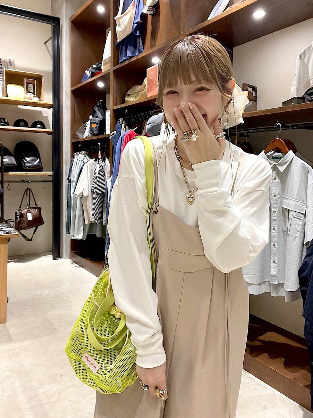 ベージュ系のスニーカー、イエロー系のショルダーバッグ、ホワイト系のヘアゴムを着用したレディースの春コーディネートの6枚目の写真