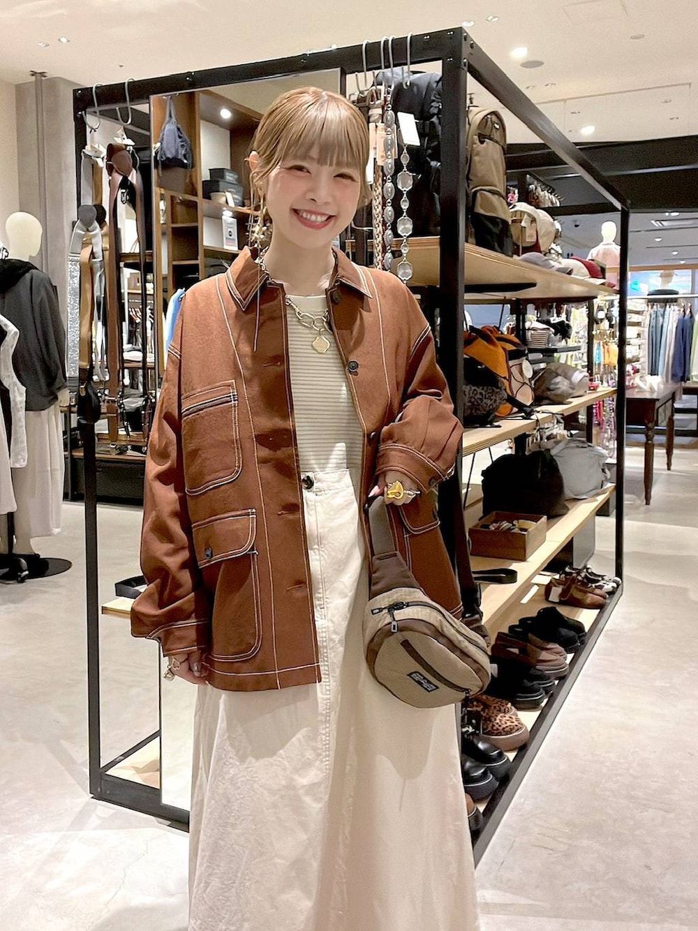 ブラウン系のカバーオール、ベージュ系のボディバッグ/ウエストポーチを着用したレディースの春コーディネートの2枚目の写真