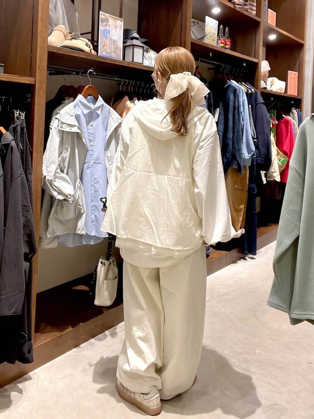 グレー系のショルダーバッグ、ホワイト系のシャツ/ブラウス、ホワイト系のベストを着用したレディースの春コーディネートの3枚目の写真