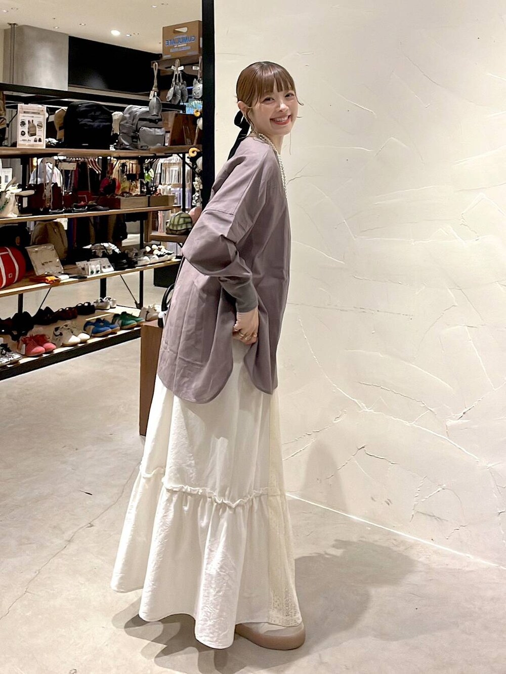 ベージュ系のスカート、ブラウン系のショルダーバッグ、ベージュ系のネックレスを着用したレディースの夏コーディネートの2枚目の写真