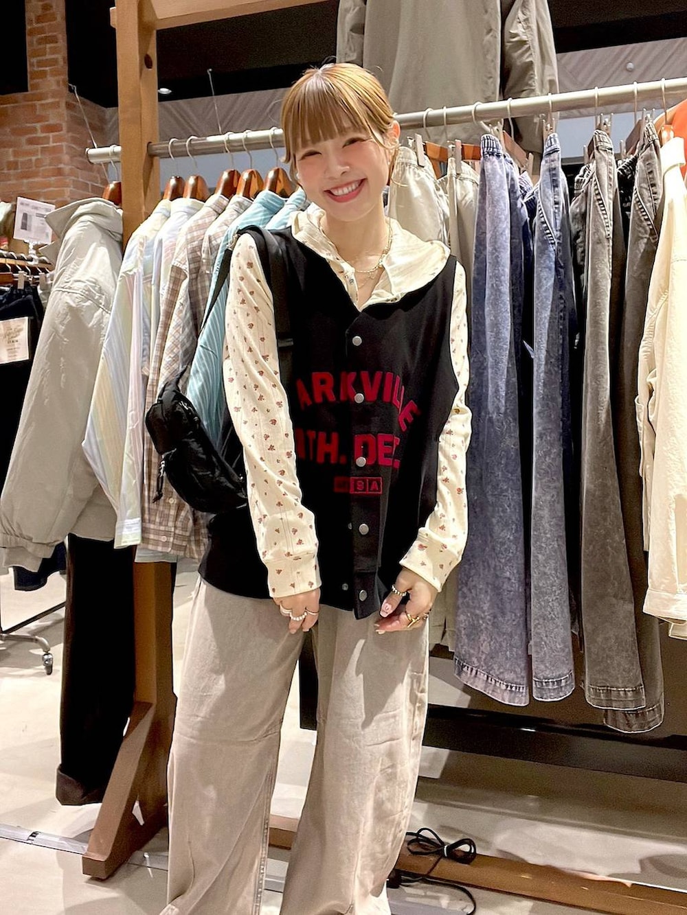 ピンク系のデニムパンツ、ベージュ系のスニーカー、ブラック系のボディバッグ/ウエストポーチを着用したレディースの冬コーディネートの7枚目の写真