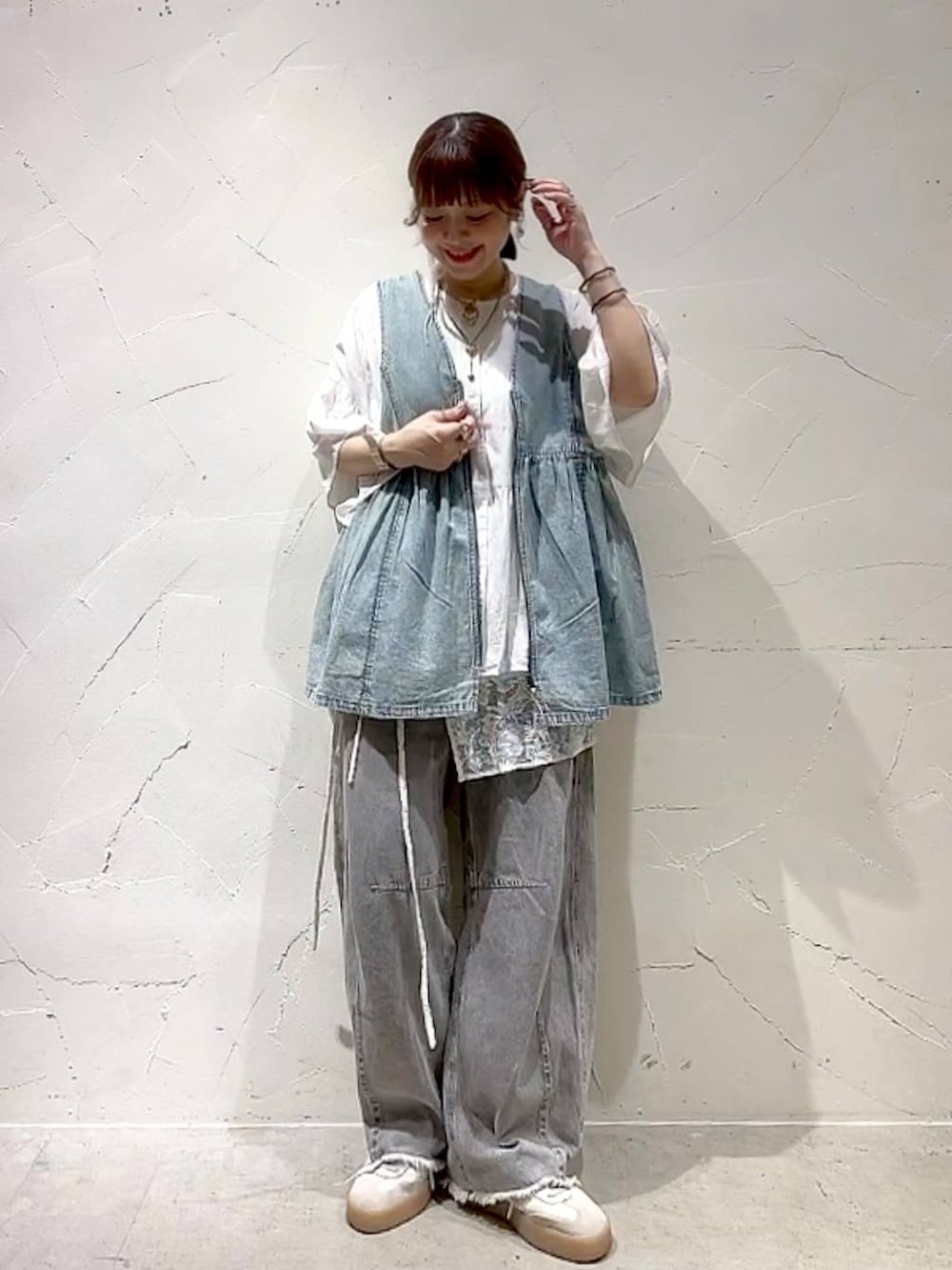 グレー系のその他パンツ、ブルー系のベスト、ホワイト系のシャツ/ブラウスを着用したレディースの夏コーディネートの3枚目の写真