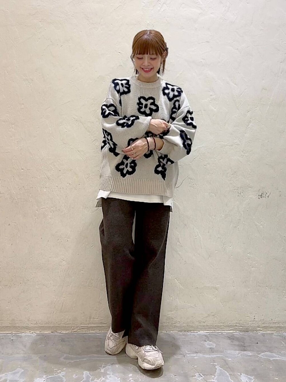 ホワイト系のTシャツ/カットソー、ブラウン系のその他パンツ、ベージュ系のニット/セーターを着用したレディースの冬コーディネートの7枚目の写真