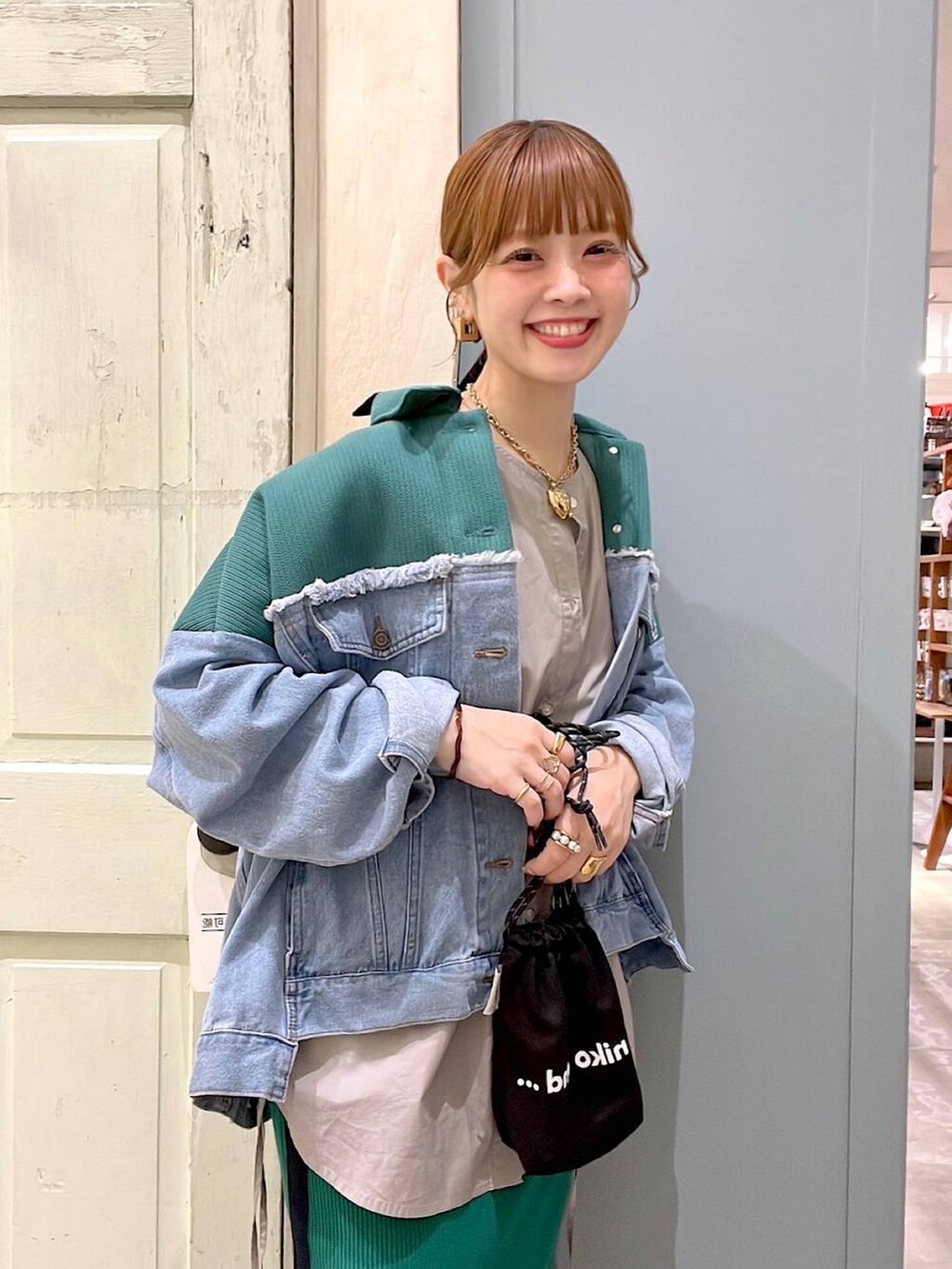 ブルー系のデニムジャケット、グレー系のシャツ/ブラウス、グリーン系のスカートを着用したレディースの春コーディネートの2枚目の写真