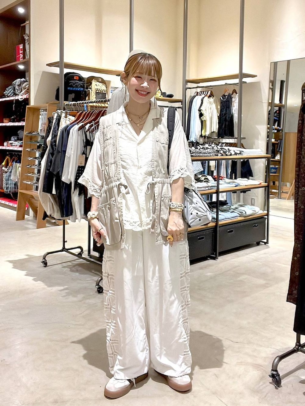 ベージュ系のベスト、ホワイト系のその他パンツ、その他のショルダーバッグを着用したレディースの夏コーディネートの2枚目の写真