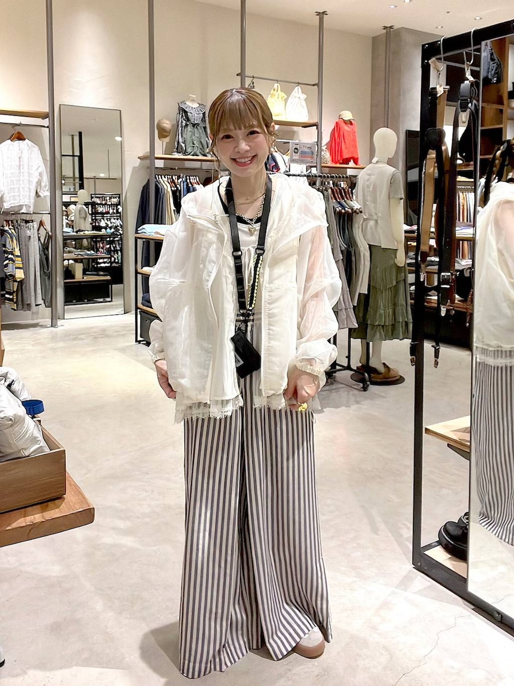 ブルー系のその他パンツ、ホワイト系のベスト、ホワイト系のタンクトップを着用したレディースの春コーディネートの2枚目の写真
