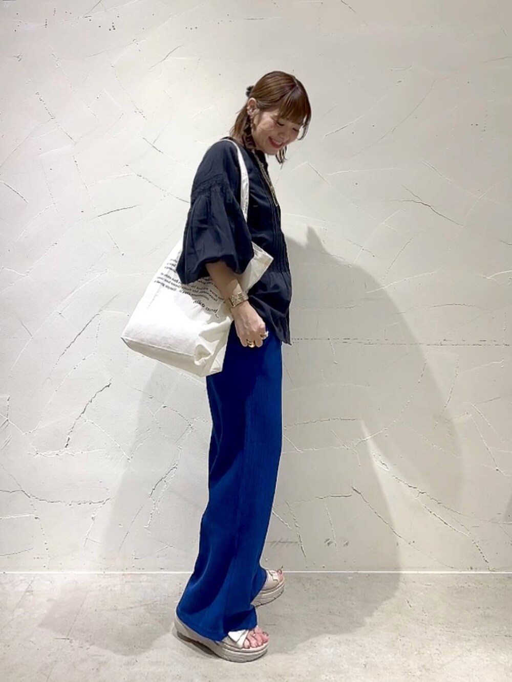 ベージュ系のトートバッグ、ブラック系のシャツ/ブラウス、ブルー系のその他パンツを着用したレディースの春コーディネートの4枚目の写真