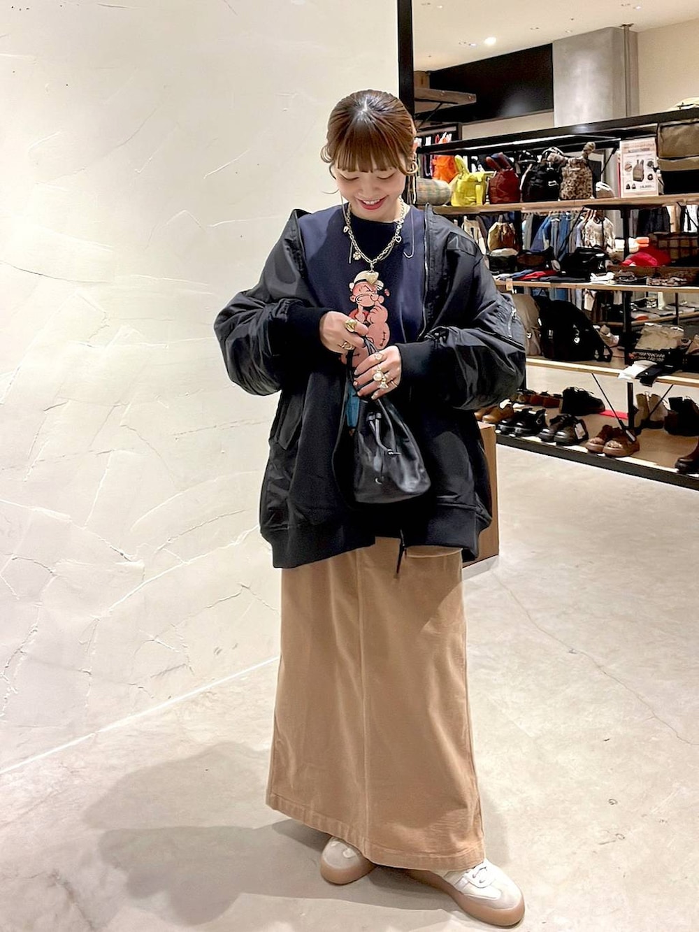 ブラック系のMA-1、イエロー系のスカート、ブルー系のスウェットを着用したレディースの冬コーディネートの5枚目の写真