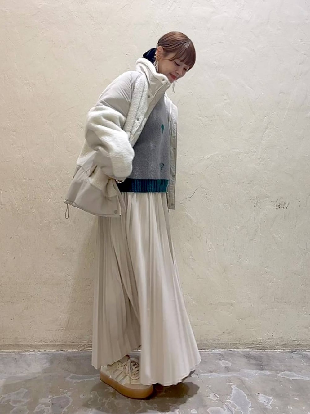 ベージュ系のスカート、ベージュ系のブルゾン、グレー系のニット/セーターを着用したレディースの秋コーディネートの3枚目の写真