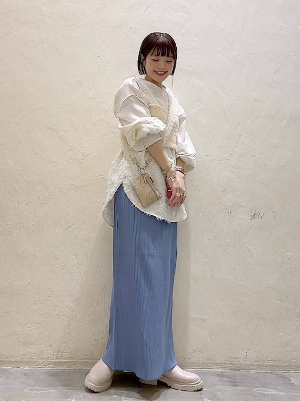 ベージュ系のシャツ/ブラウス、ベージュ系のベスト、ベージュ系のブーツを着用したレディースの冬コーディネートの6枚目の写真