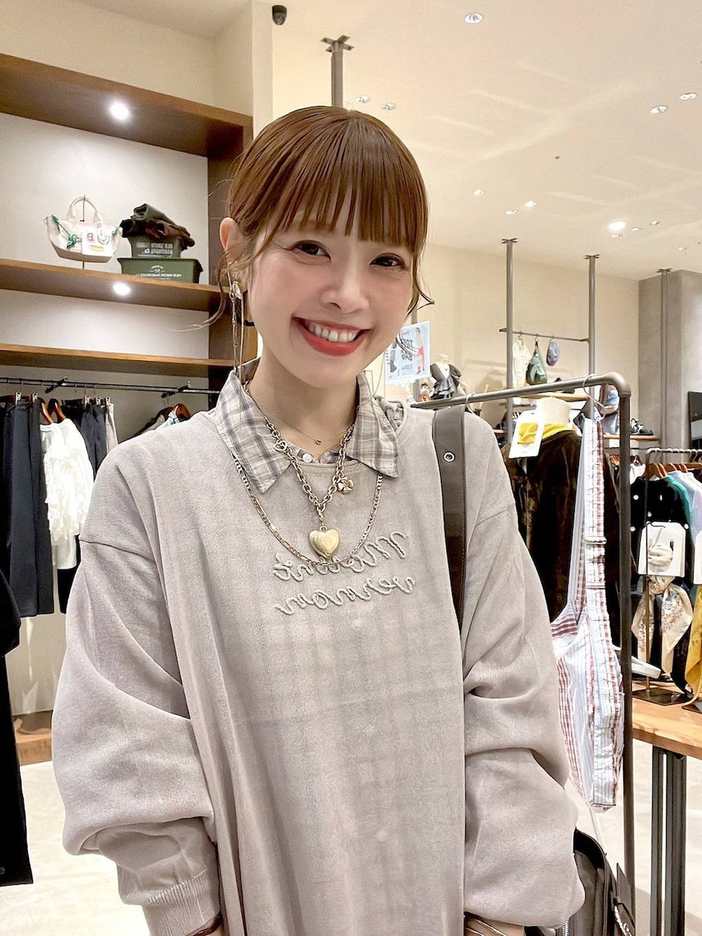 ブルー系のスカート、ホワイト系のシャツ/ブラウス、ブラウン系のショルダーバッグを着用したレディースの秋コーディネートの2枚目の写真