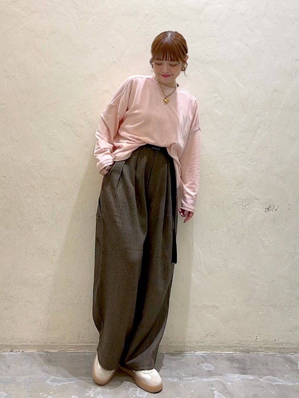 ブラウン系のその他パンツ、ピンク系のTシャツ/カットソー、イエロー系のリングを着用したレディースの冬コーディネートの2枚目の写真