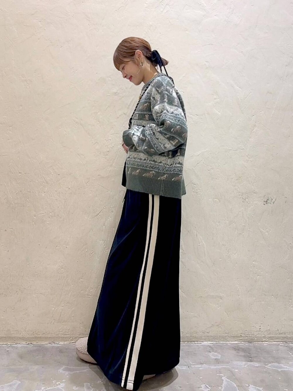 ブラック系のショルダーバッグ、ベージュ系のスリッポン、ブラック系のスカートを着用したレディースの冬コーディネートの7枚目の写真