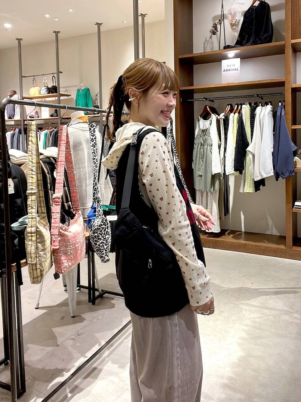 ピンク系のデニムパンツ、ベージュ系のスニーカー、ブラック系のボディバッグ/ウエストポーチを着用したレディースの冬コーディネートの3枚目の写真