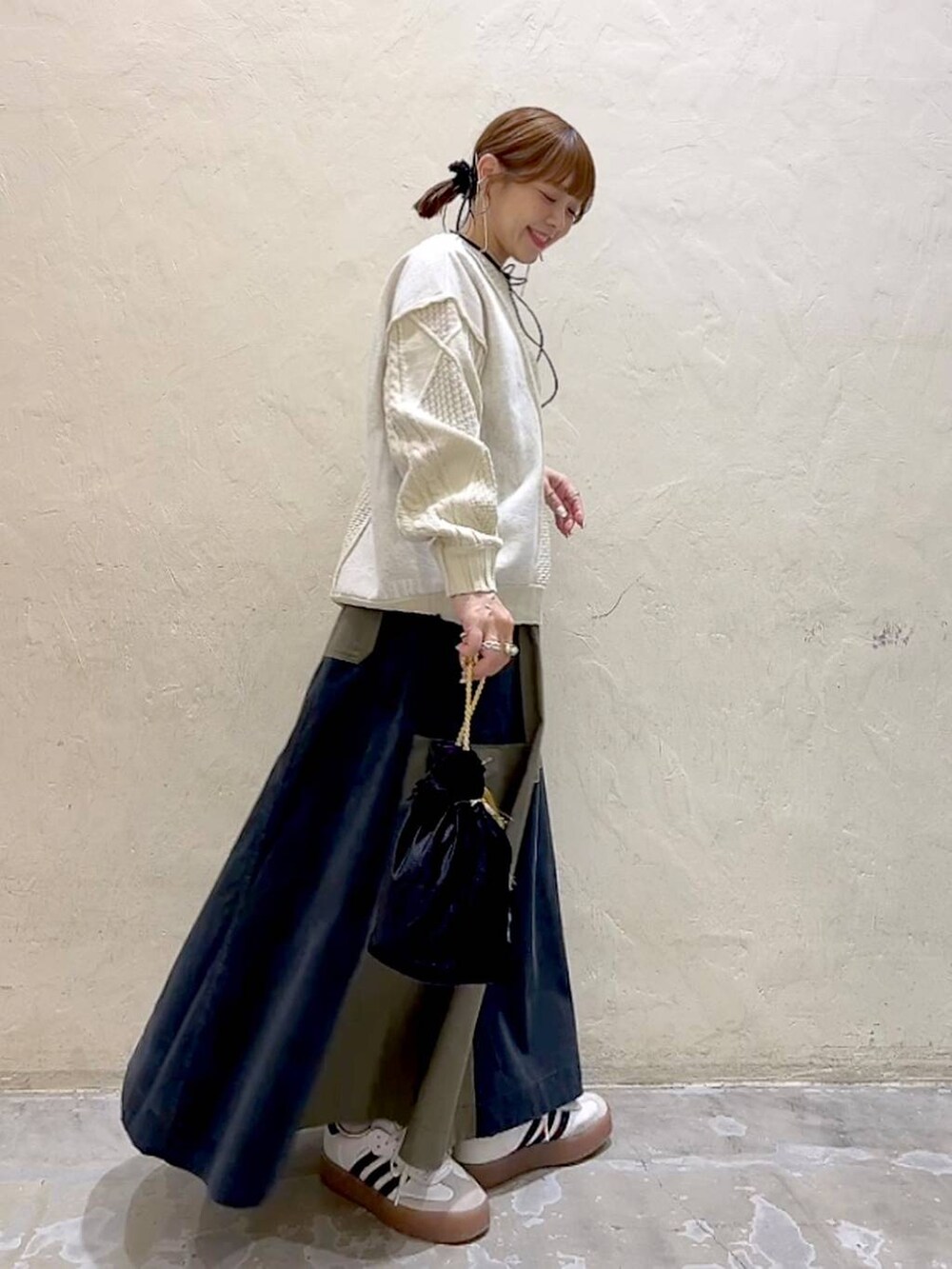 その他のショルダーバッグ、ベージュ系のニット/セーター、グリーン系のスカートを着用したレディースの冬コーディネートの4枚目の写真