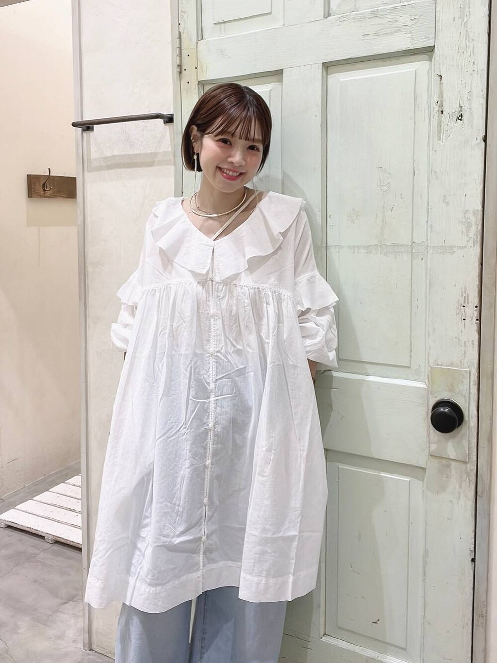 イエロー系のサンダル、ブルー系のその他パンツ、ホワイト系のチュニックを着用したレディースの春コーディネートの4枚目の写真