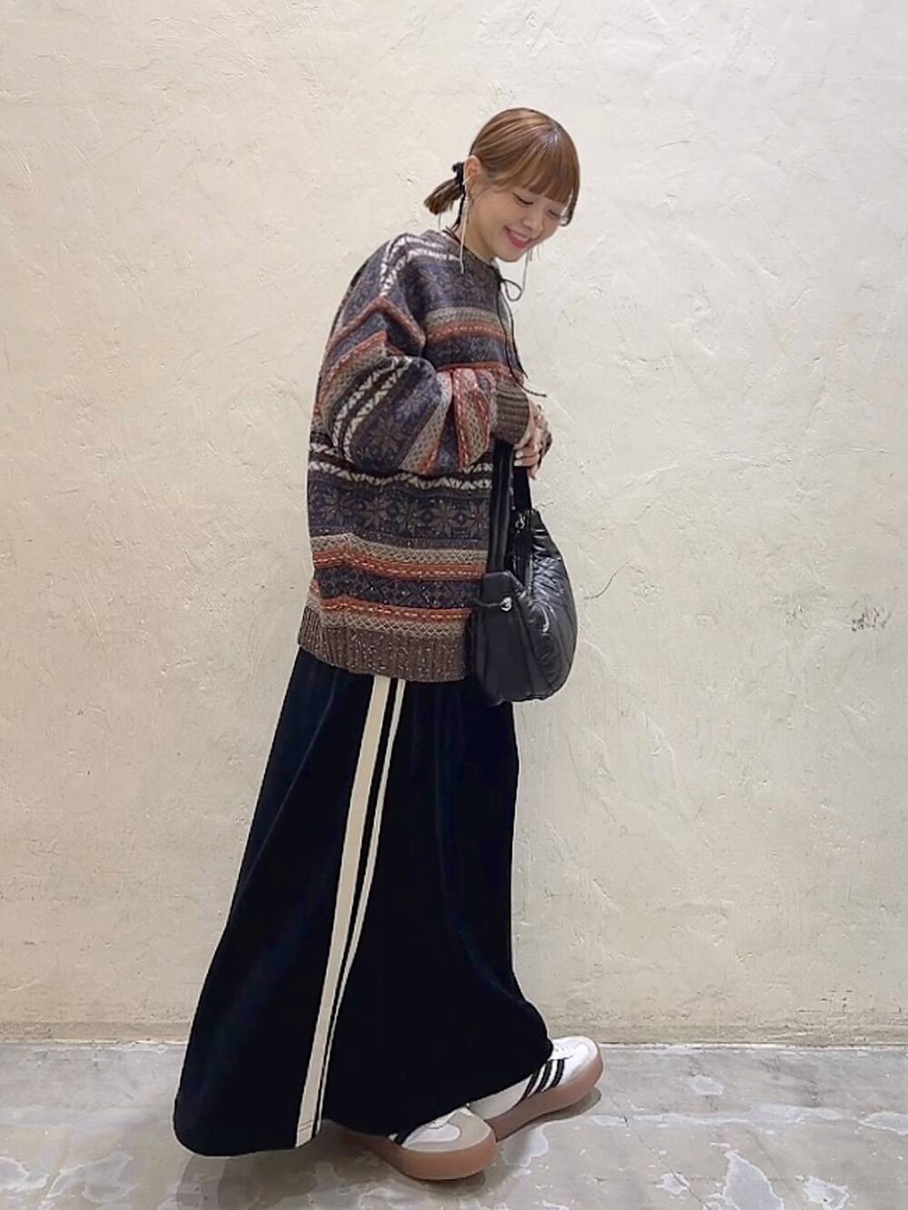 ブラック系のショルダーバッグ、ブラウン系のニット/セーター、ブラック系のスカートを着用したレディースの冬コーディネートの4枚目の写真