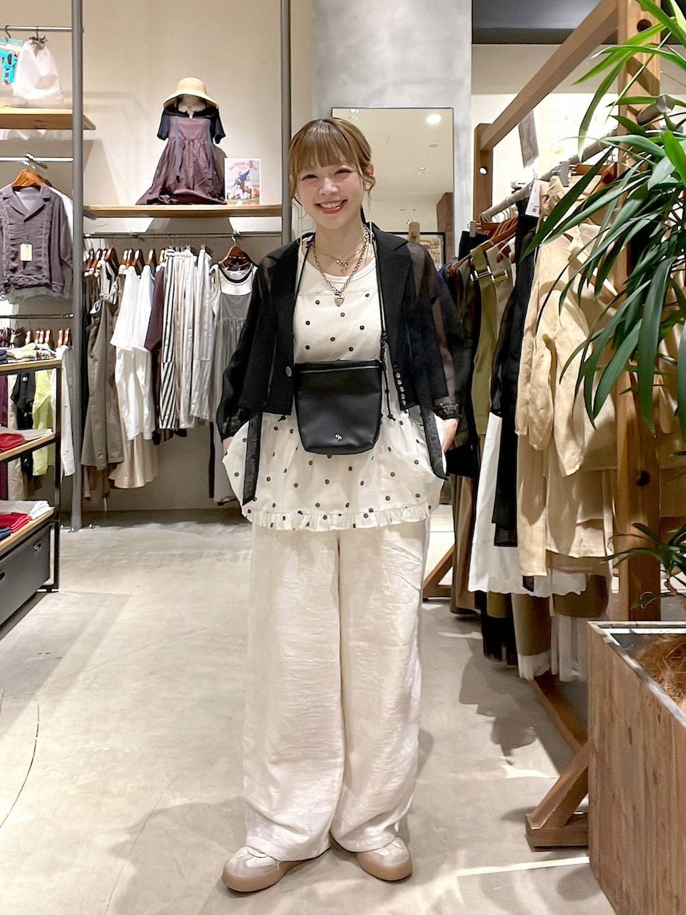 ホワイト系のタンクトップ、ベージュ系のその他パンツ、ブラック系のショルダーバッグを着用したレディースの夏コーディネートの2枚目の写真