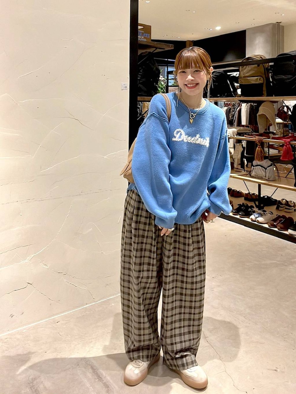 ブラウン系のその他パンツ、ブルー系のニット/セーター、ベージュ系のボストンバッグを着用したレディースの秋コーディネートの3枚目の写真